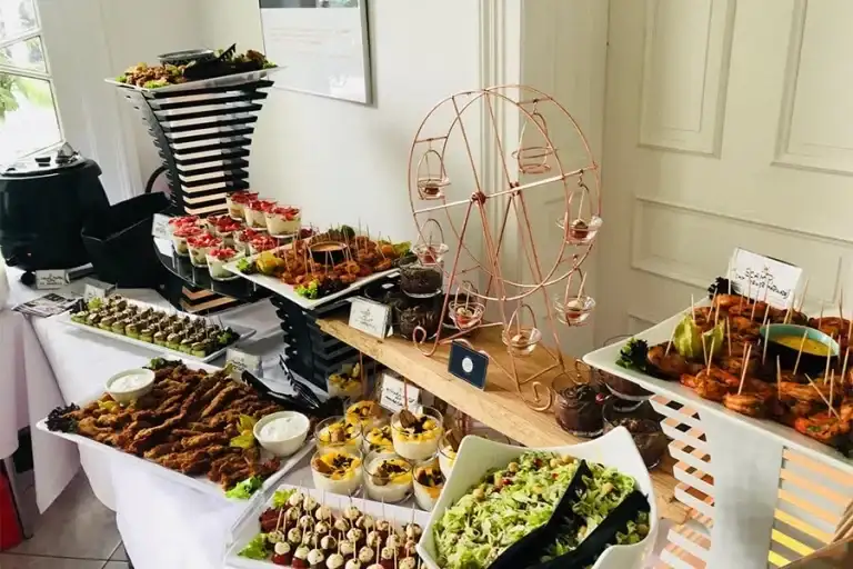 Diverse Häppchen des warmen Buffets hübsch angerichtet auf einer langer Tafel