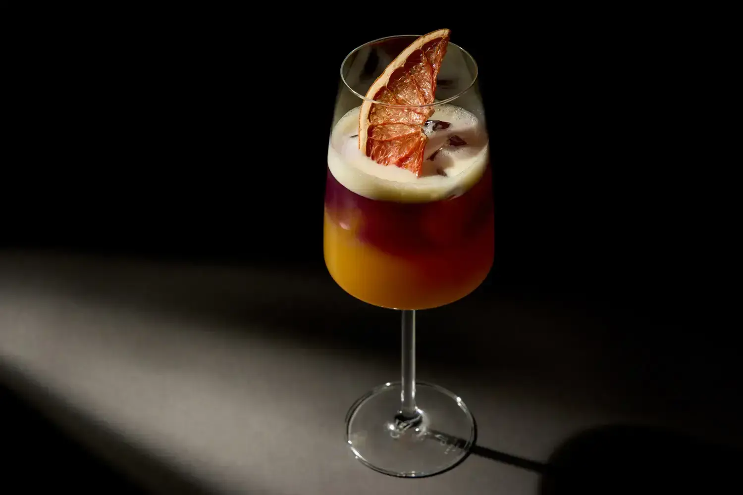 Wintercocktail mit Zitrusfrucht in einem hohen Glas