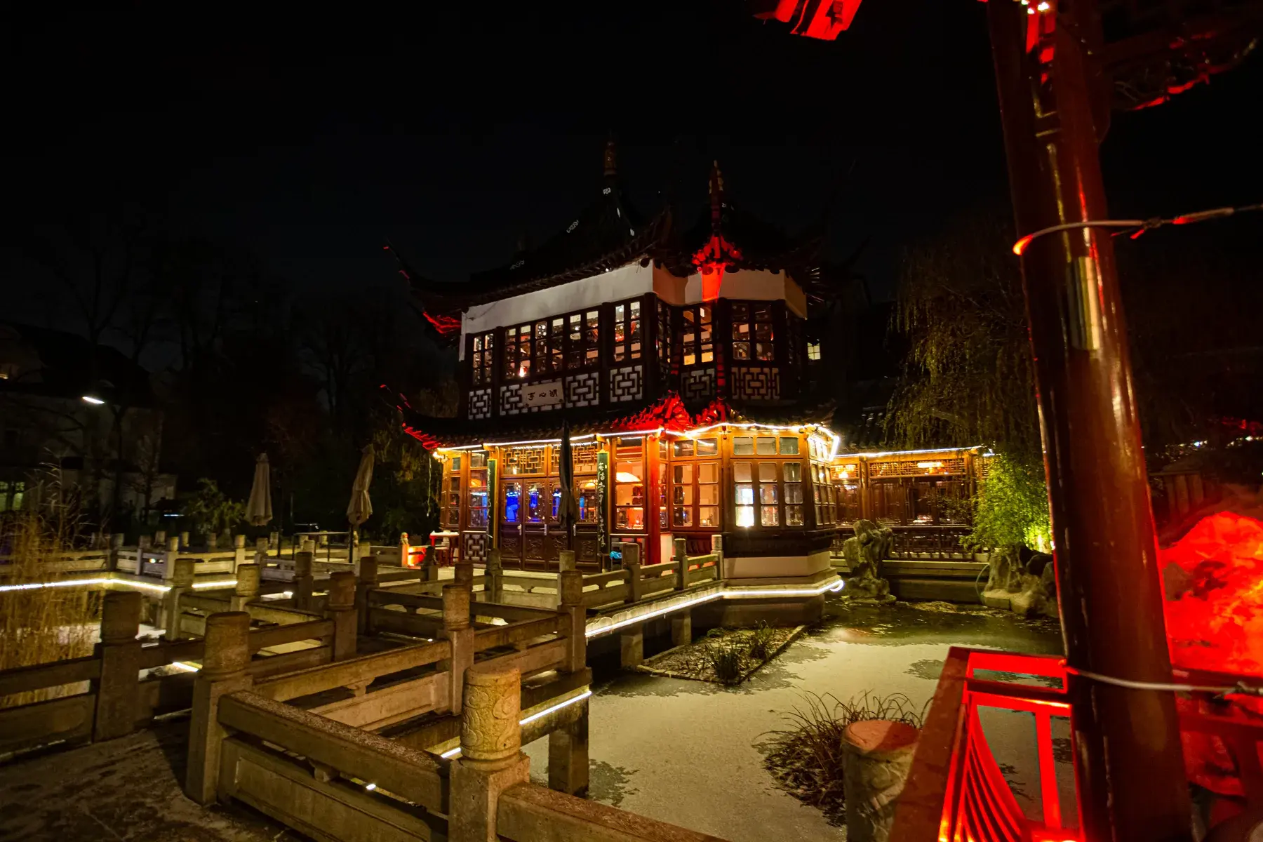 Beleuchtetes Teehaus am Wasser in der winterlichen Location